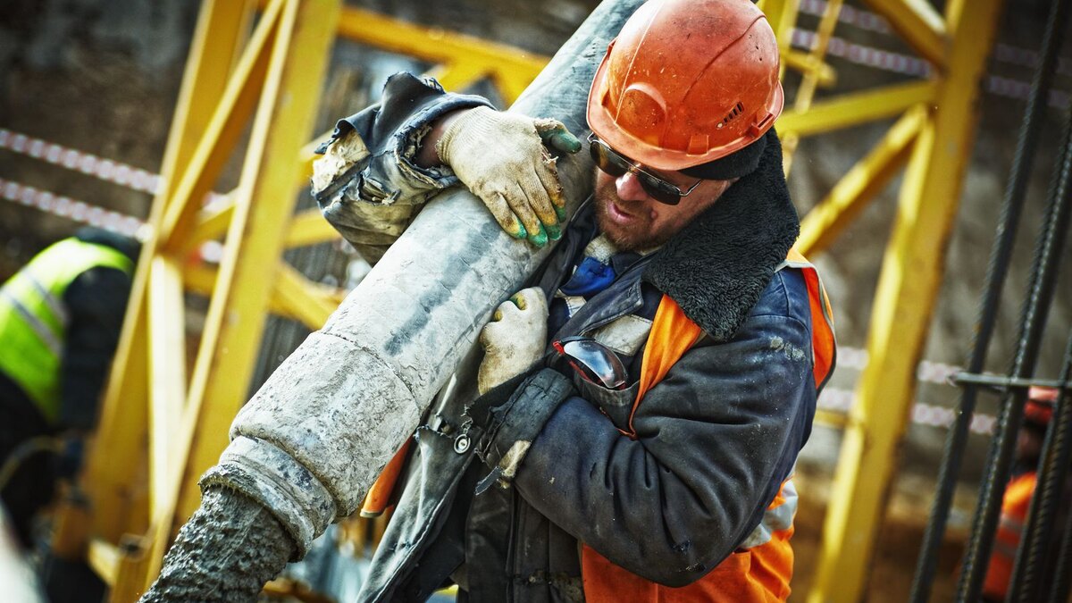 Construction worker handling a concrete line on an active job site